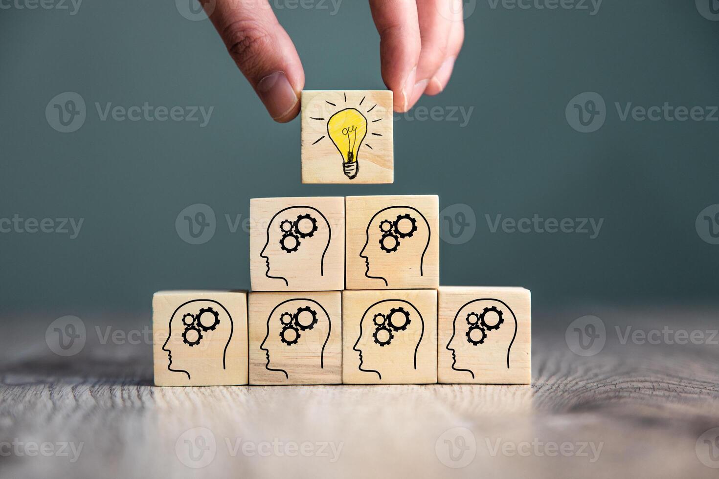 A person placing wooden blocks with a light bulb on top photo