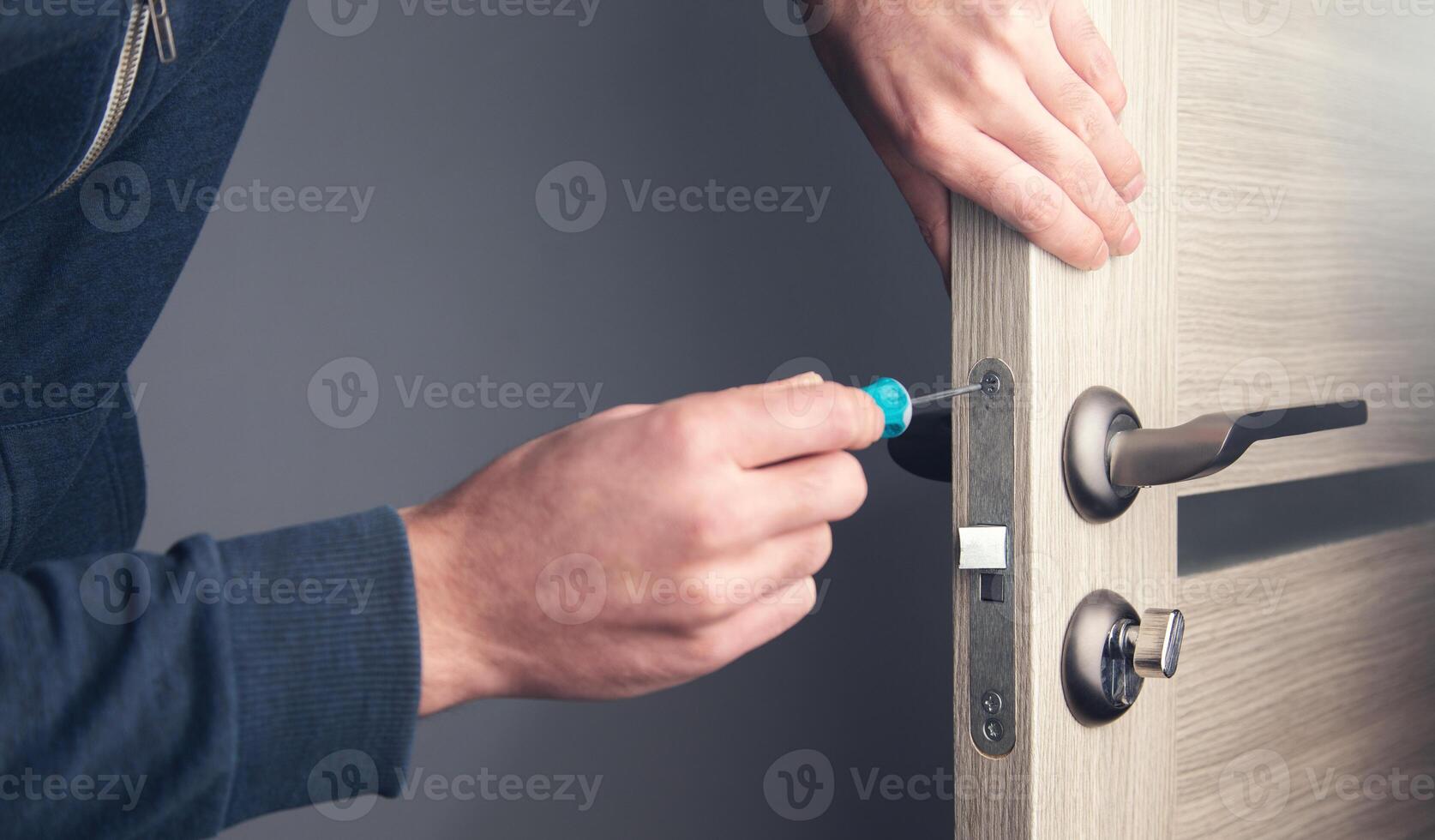 A man is fixing a door with a screwdriver photo