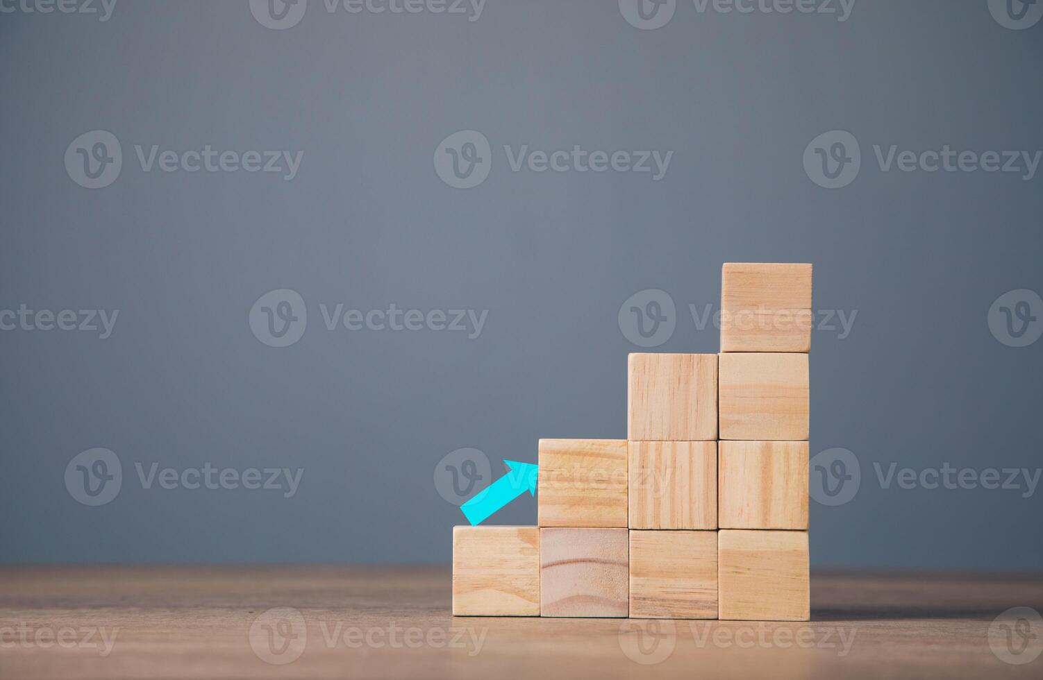 A wooden block with an arrow pointing up photo