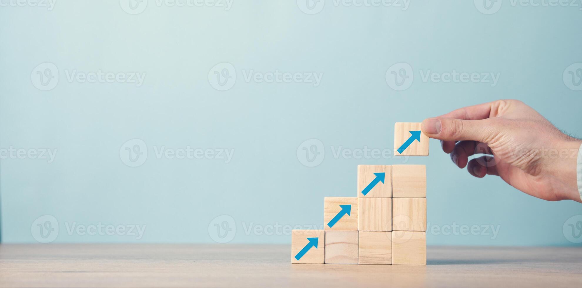 A person is placing wooden blocks on a table with arrows photo