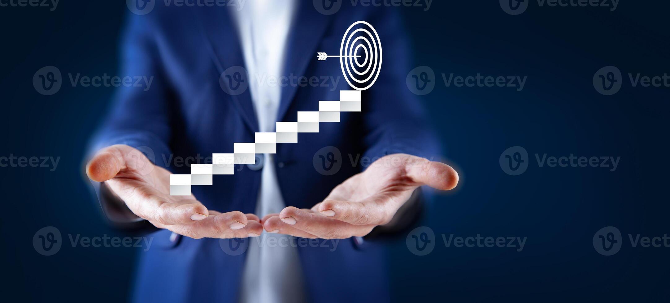 Businessman holding up a spiral staircase with a target on it photo