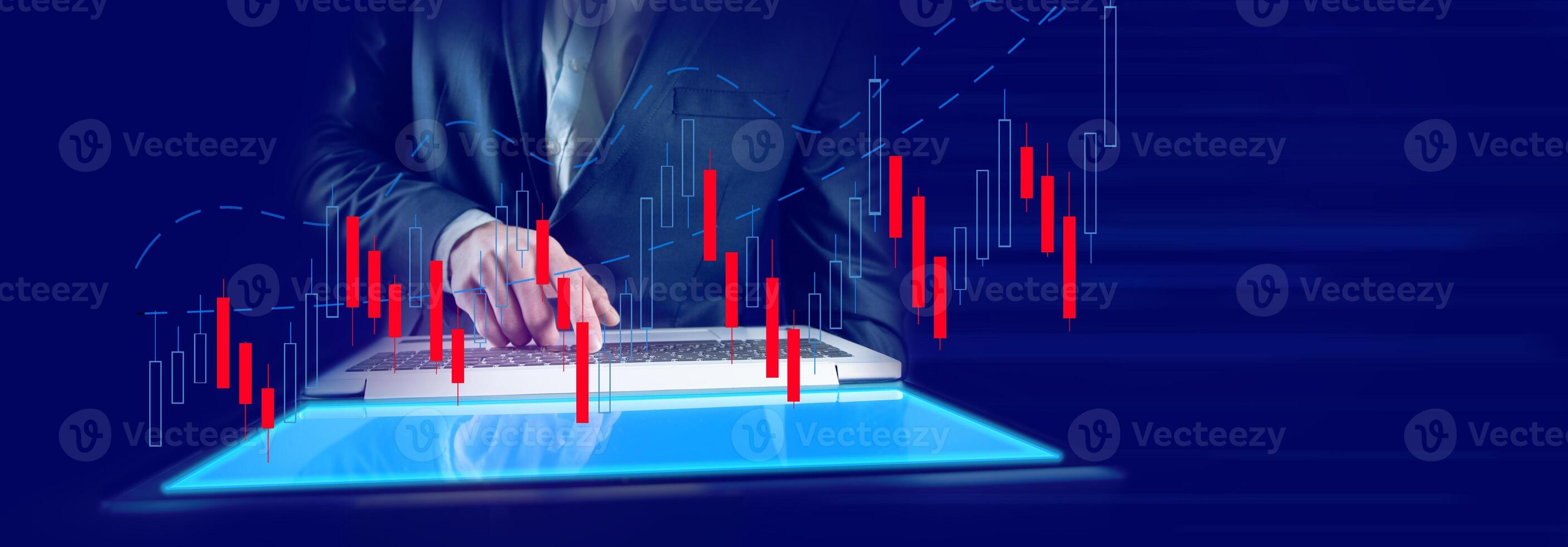 A man in a suit is using a laptop computer with a graph on it photo
