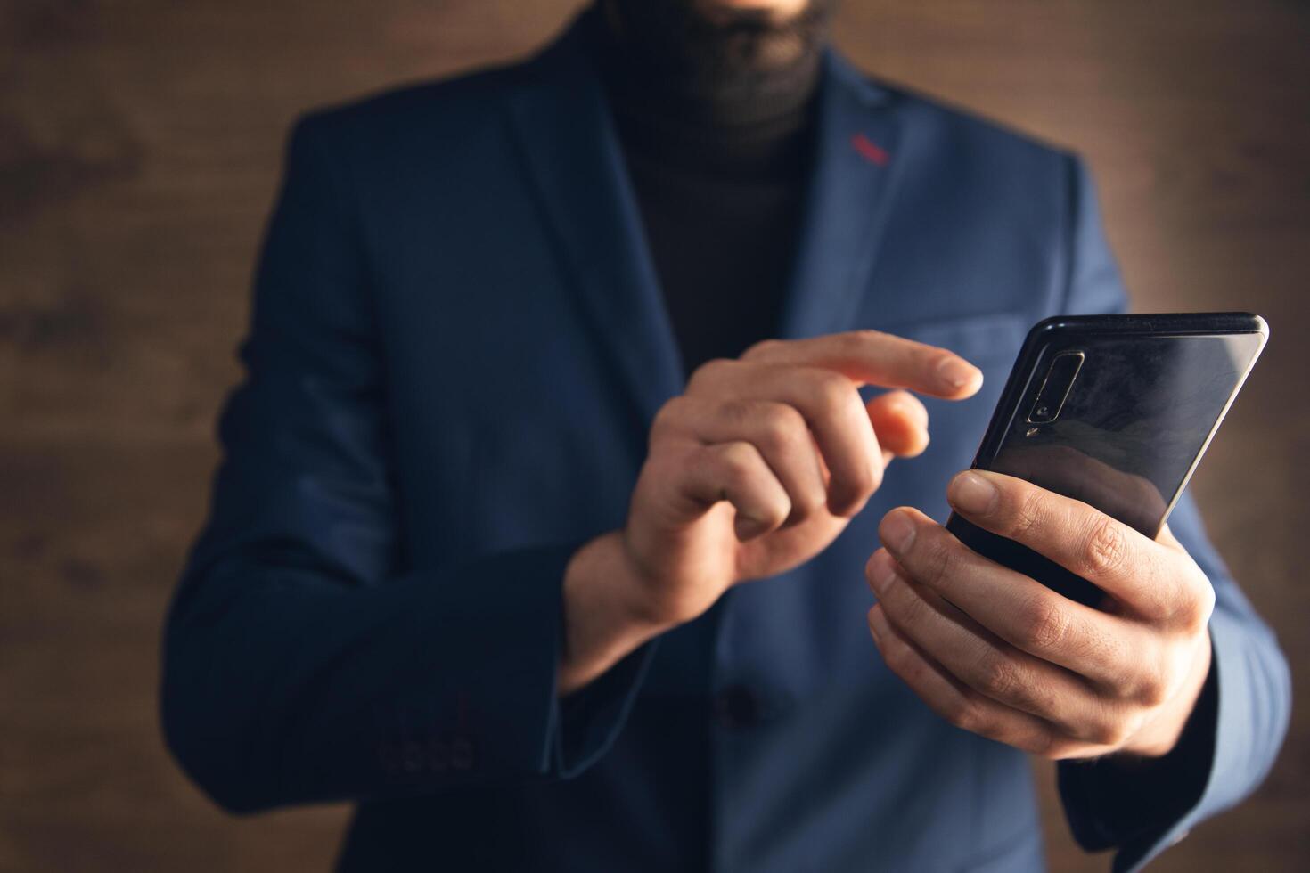 A man in a suit holding a smartphone photo