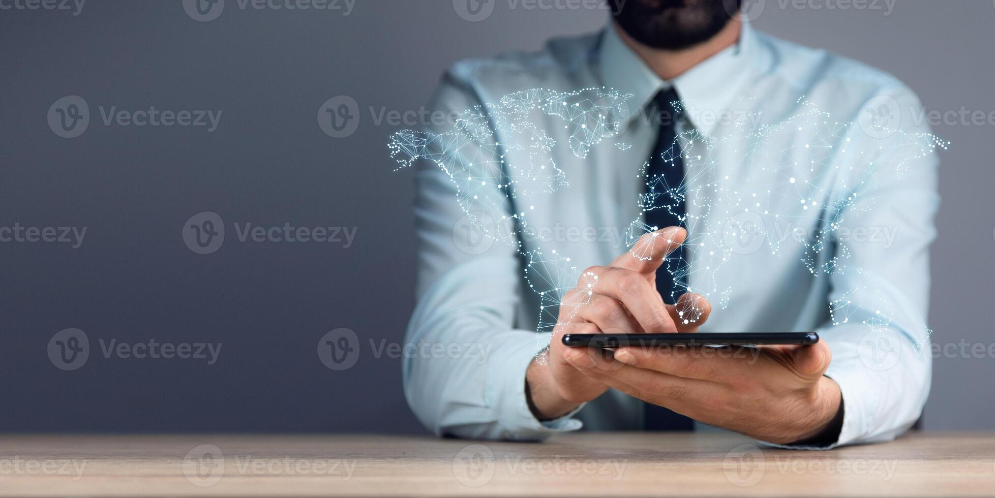 A man in a suit is holding a tablet with a digital map on it photo
