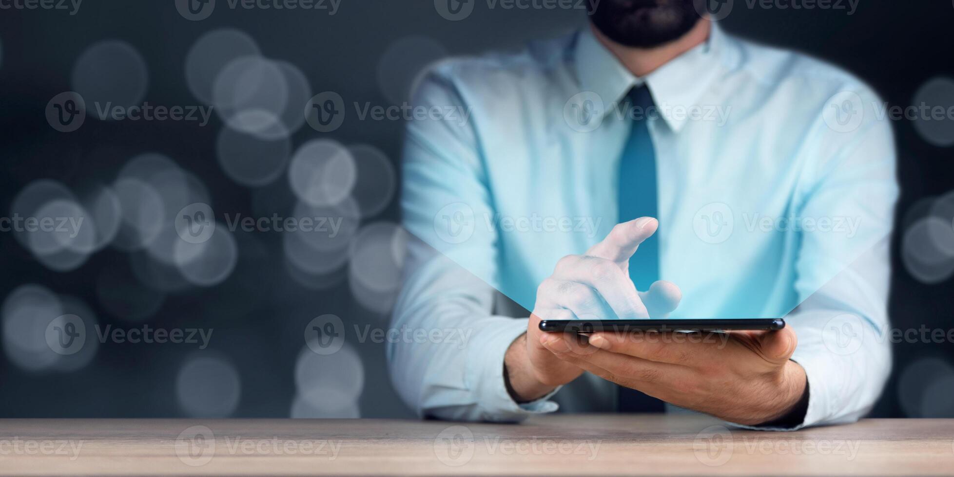 A man in a shirt and tie is using a tablet photo