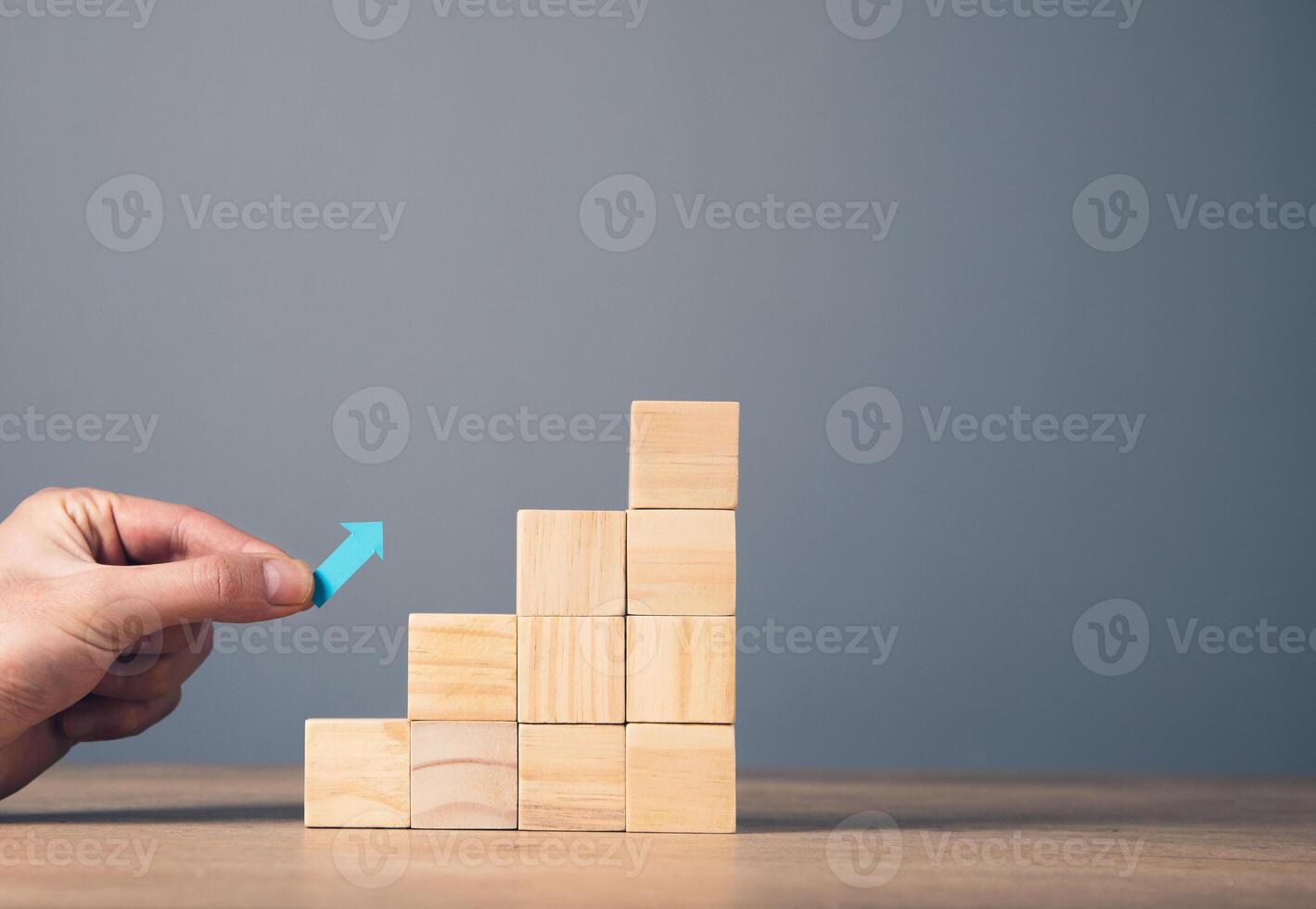 A person is placing wooden blocks on a table photo