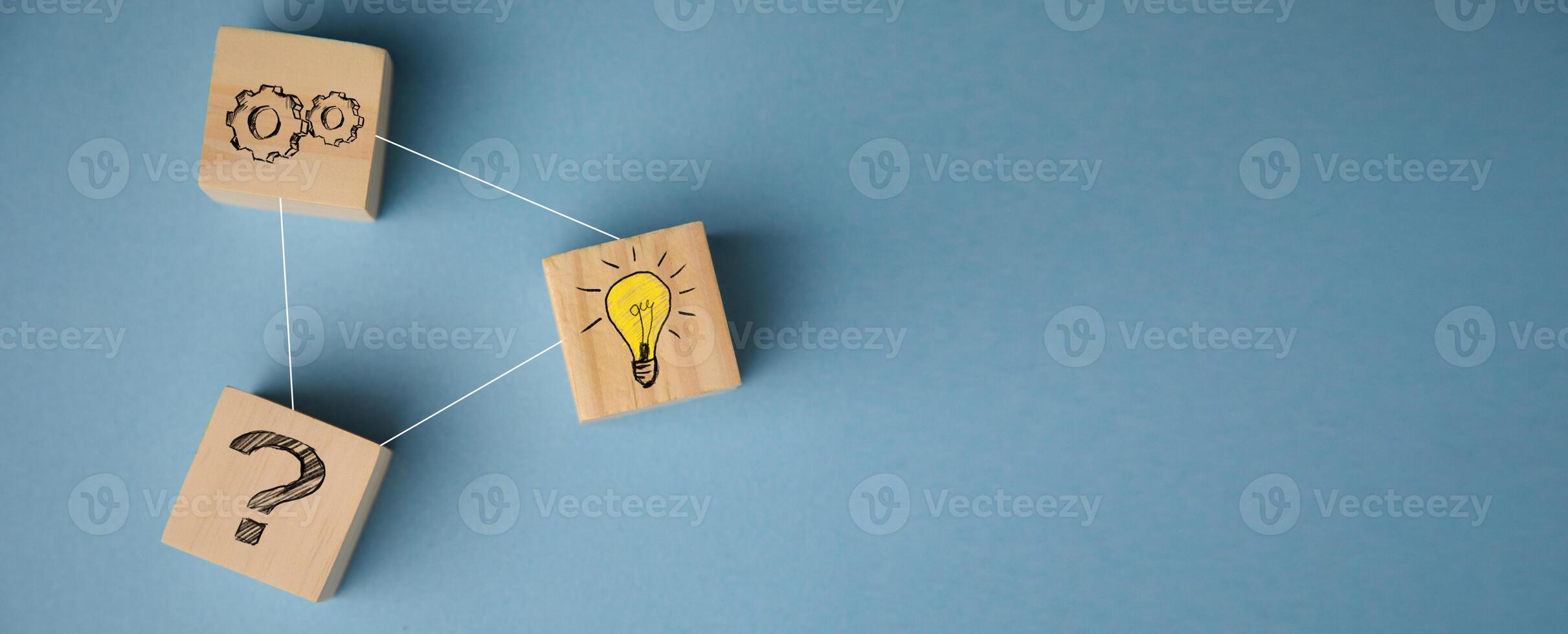 A wooden block with a light bulb, question mark and a question mark photo