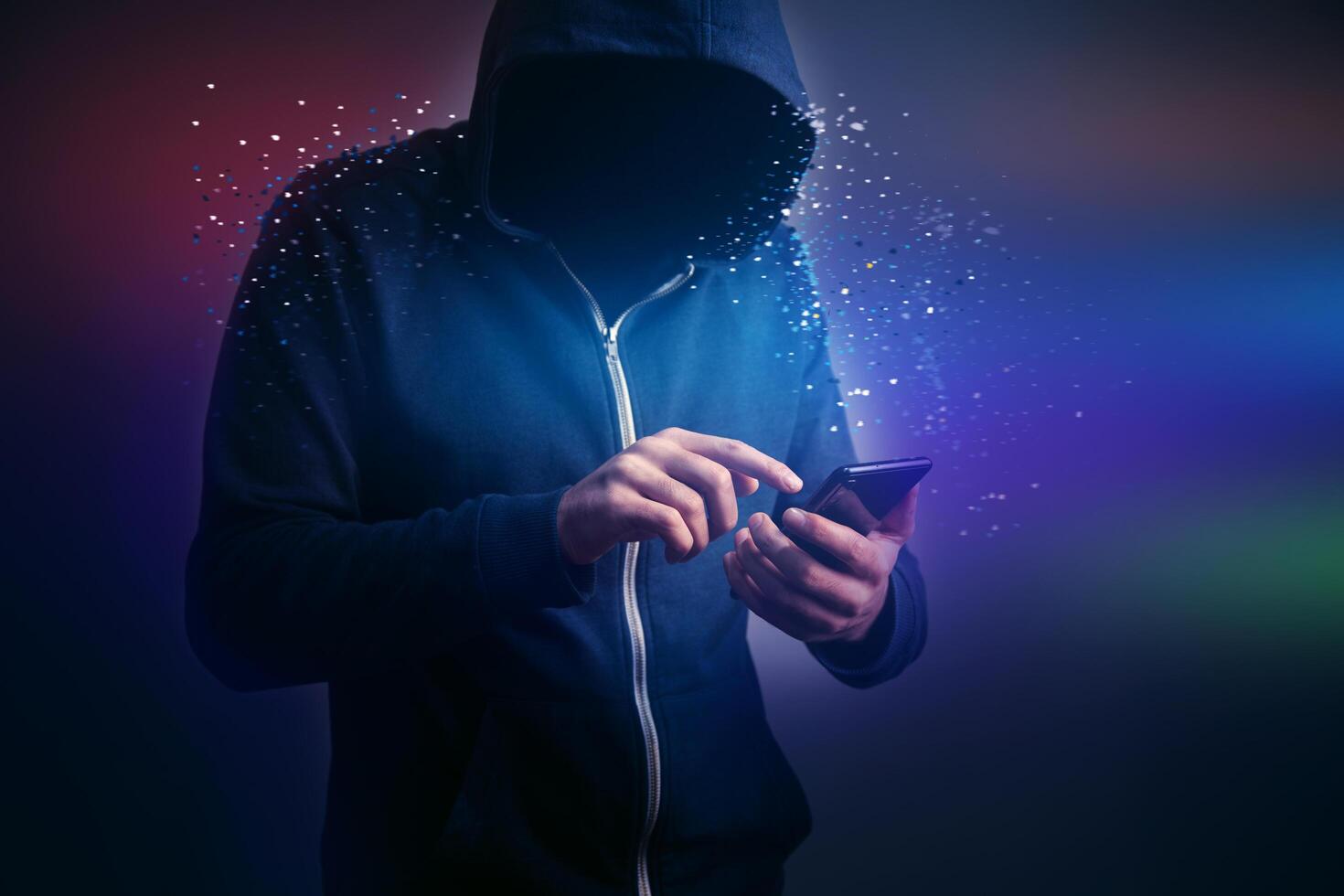 A man in a hoodie is using his phone photo