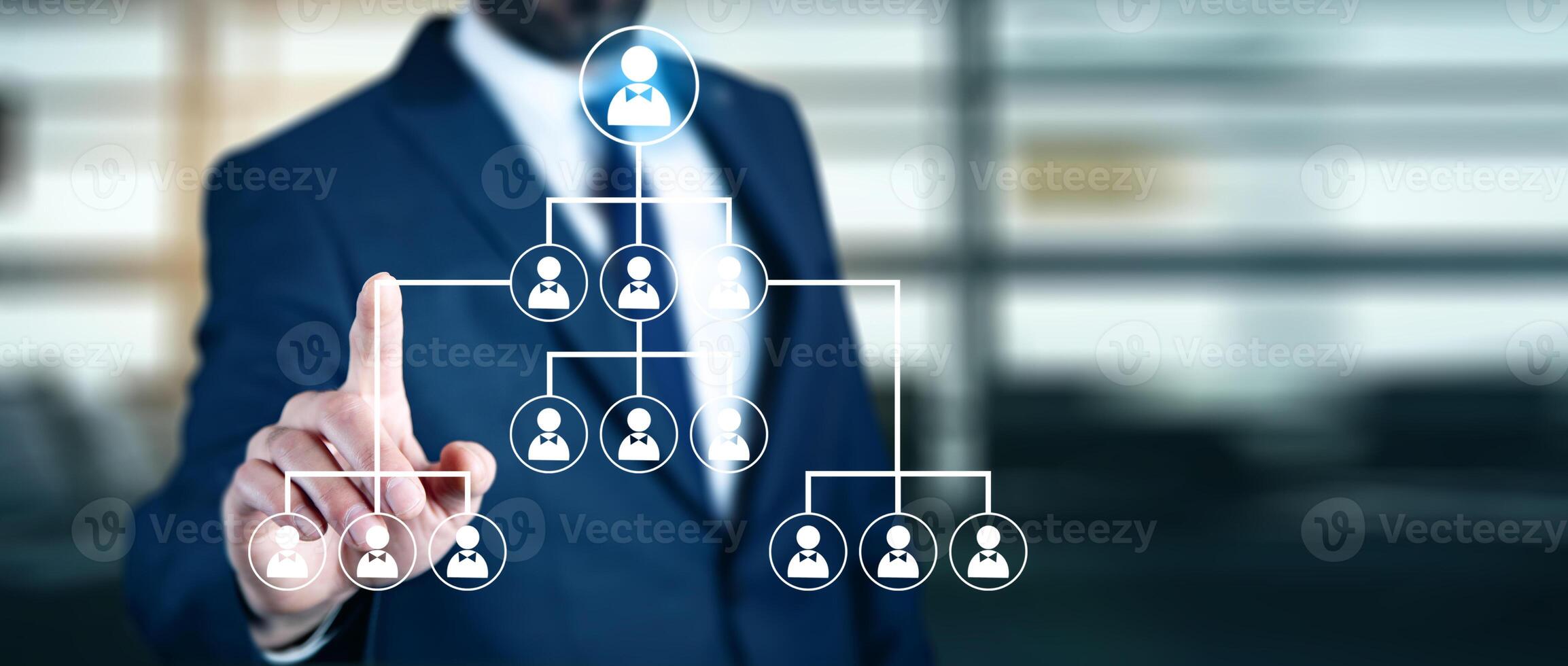 Businessman pointing to a business hierarchy on a virtual screen photo