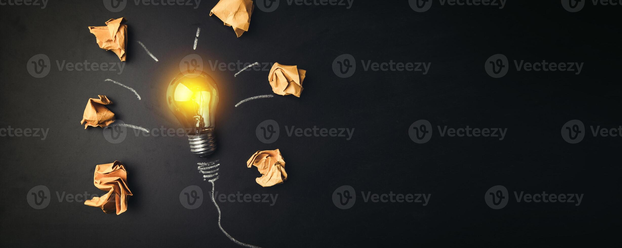 A light bulb surrounded by paper and crumpled up pieces photo