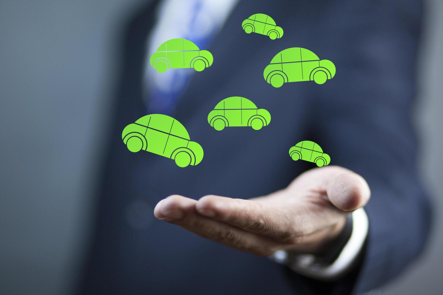 A man in a suit is holding a green car photo