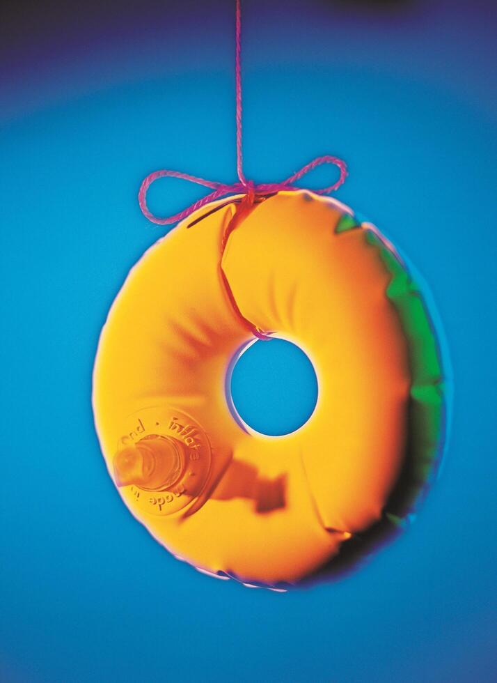 a donut hanging from a string with a red ribbon photo