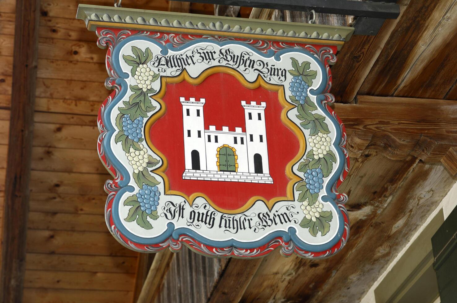 a sign hanging from a building with a castle on it photo