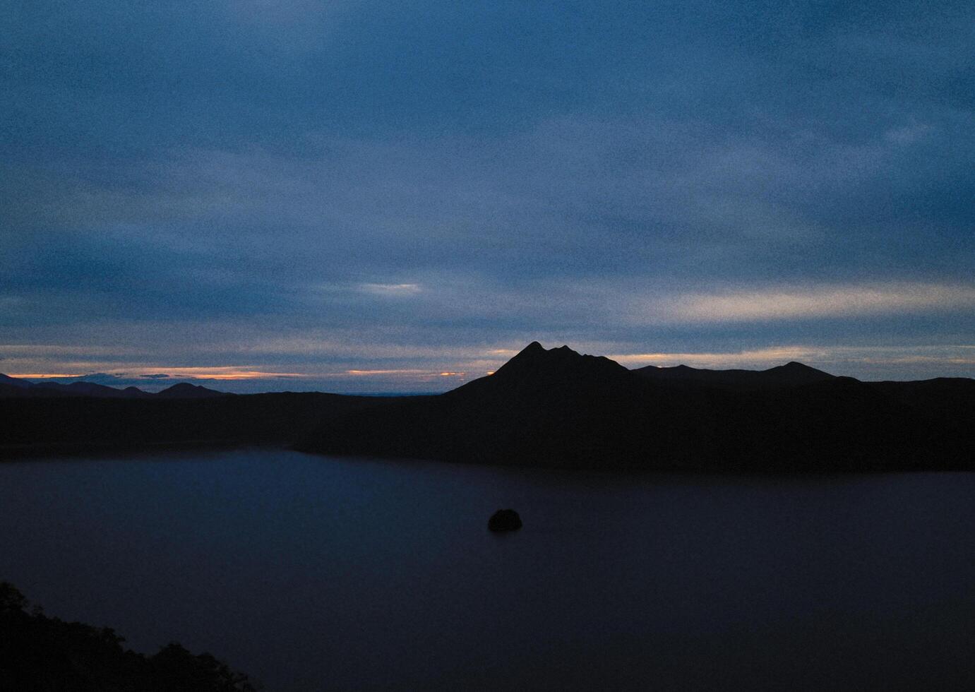a lake with mountains in the background at dusk photo