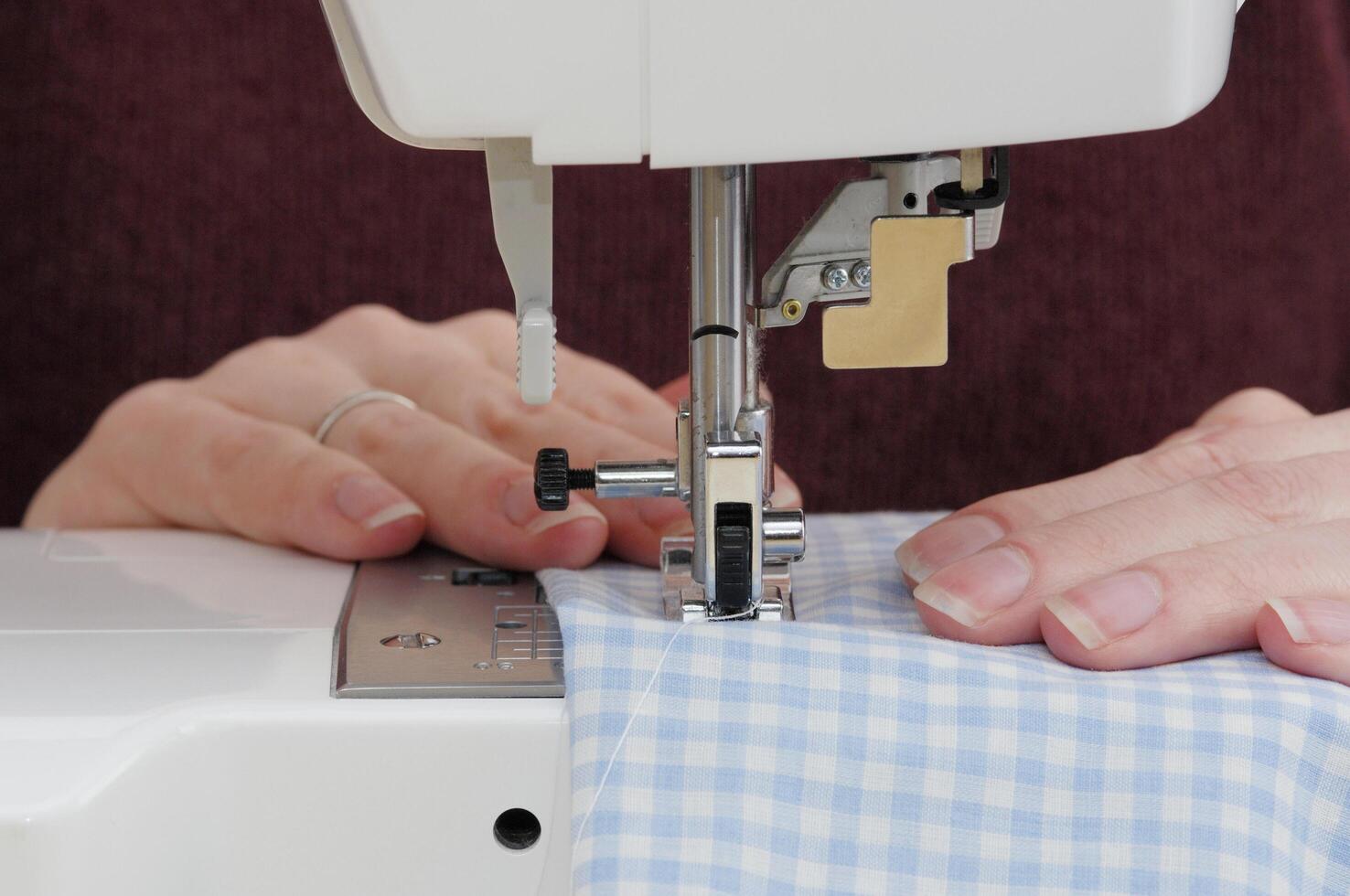 a person is sewing on a blue and white shirt photo