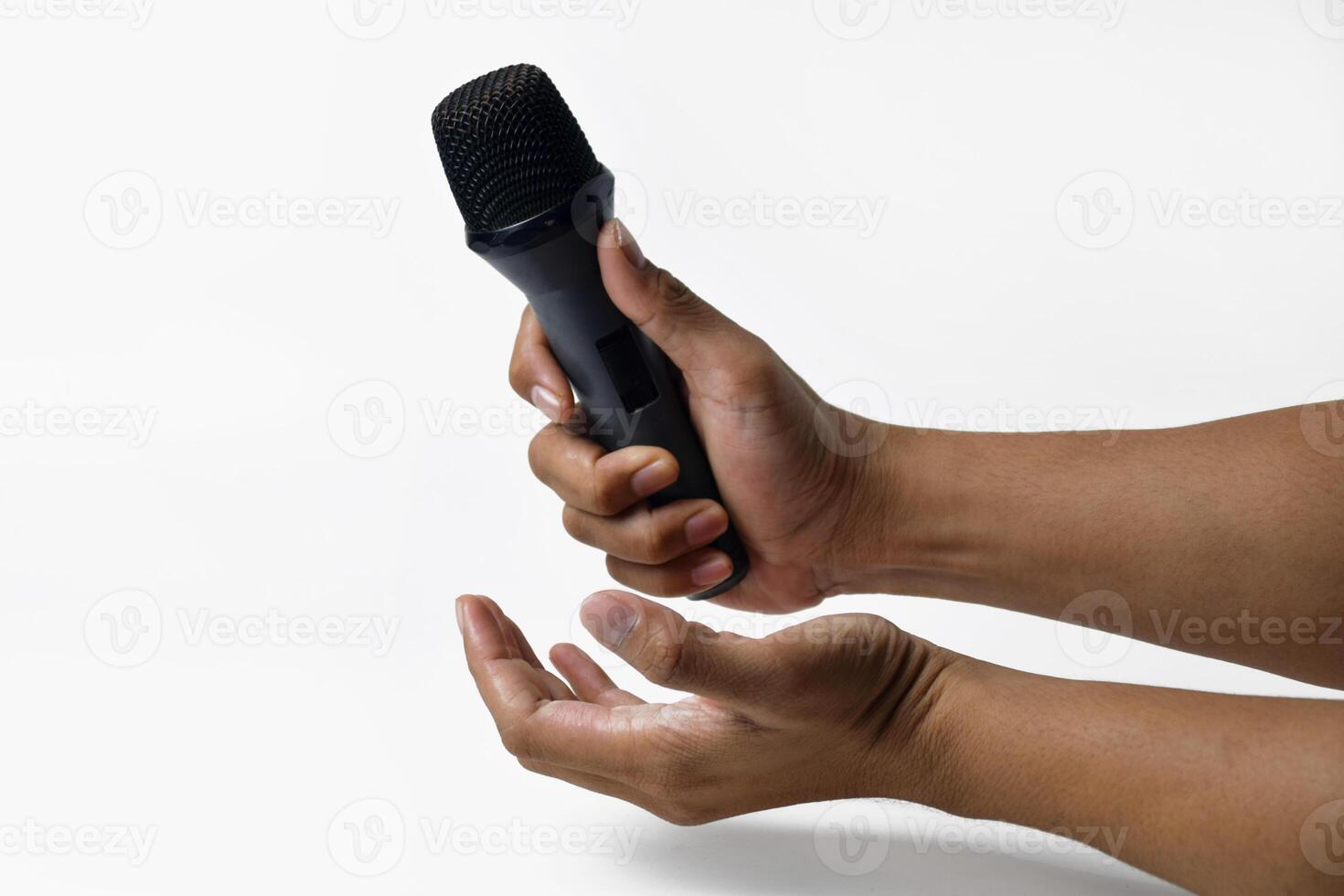 Studio shot of man holding microphone using both hands photo