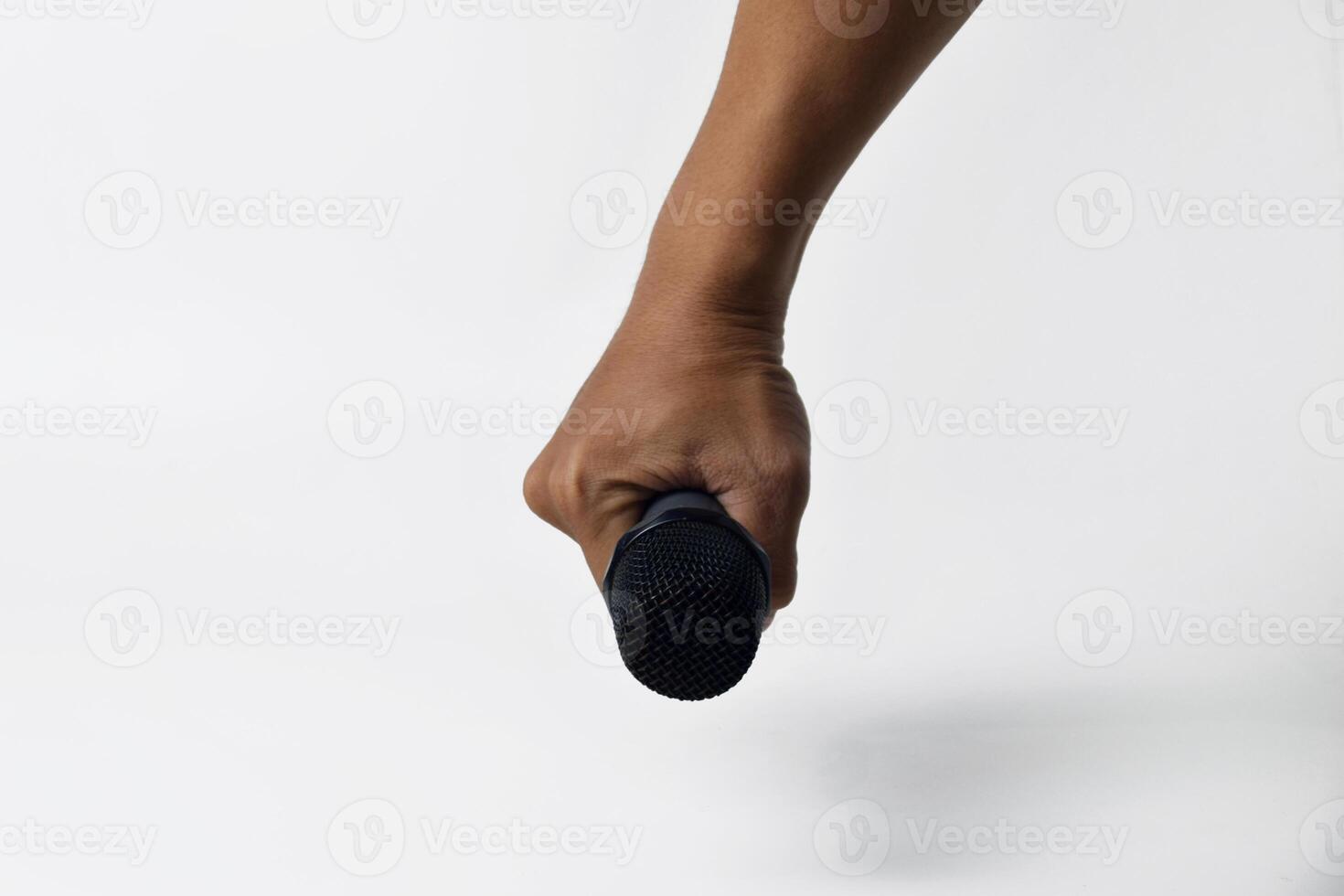 Human hand gripping microphone white backdrop photo