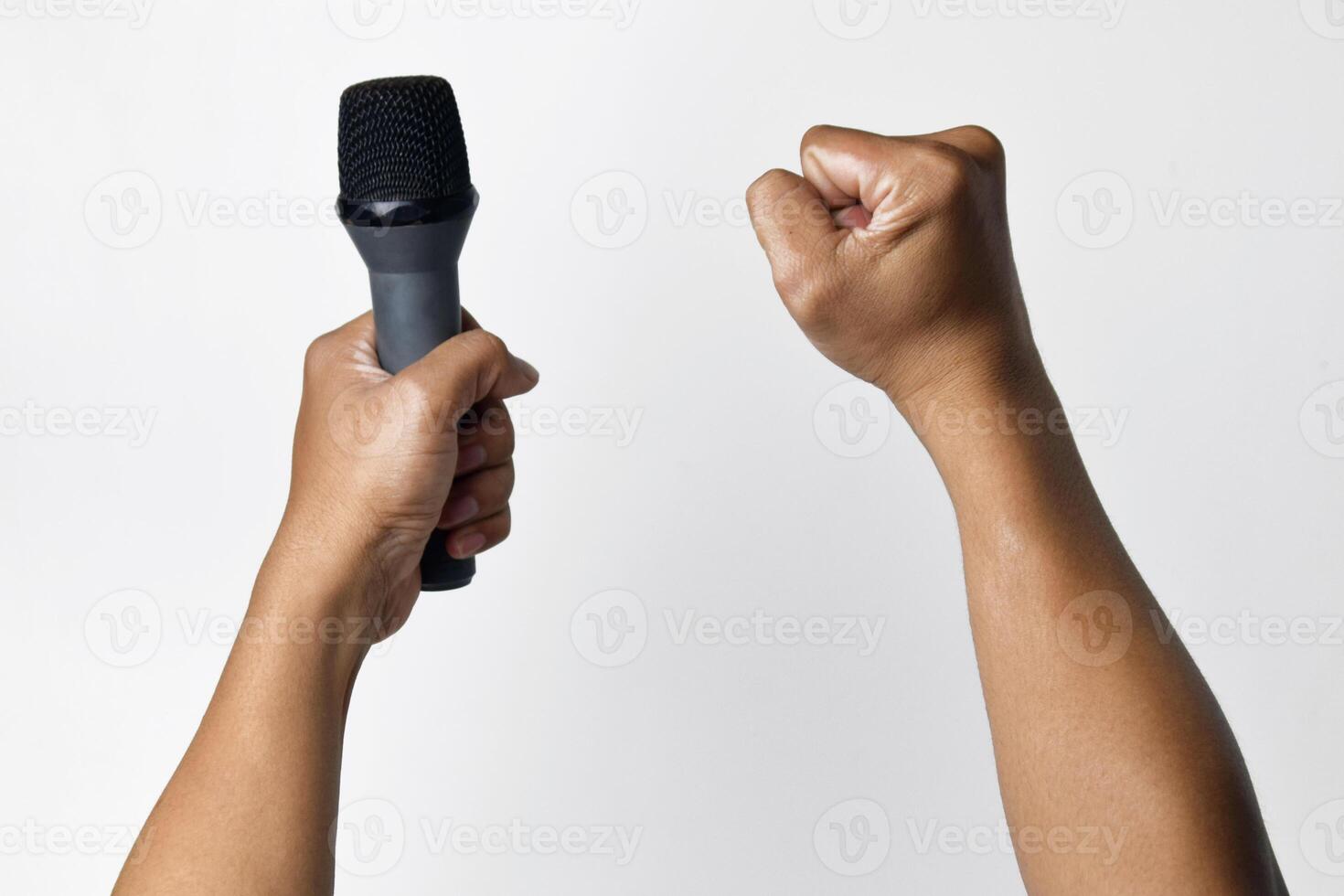 Person speaking into microphone with raised fist gesture photo
