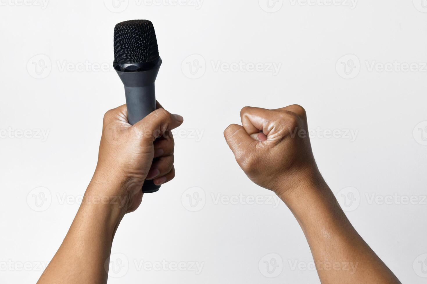 Person holding microphone and raising hand in fist on white background photo
