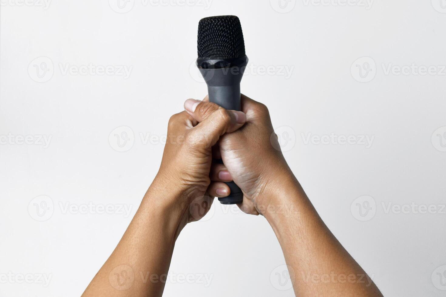Close up of hands holding microphone on white background photo