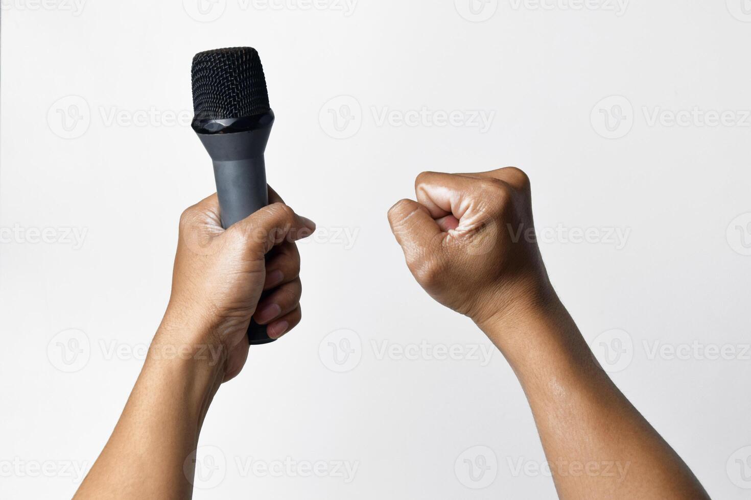 Microphone in hand and raised fist on white backdrop photo