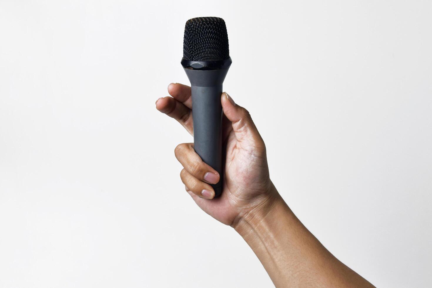 Person holding microphone viewed from low angle on white background photo