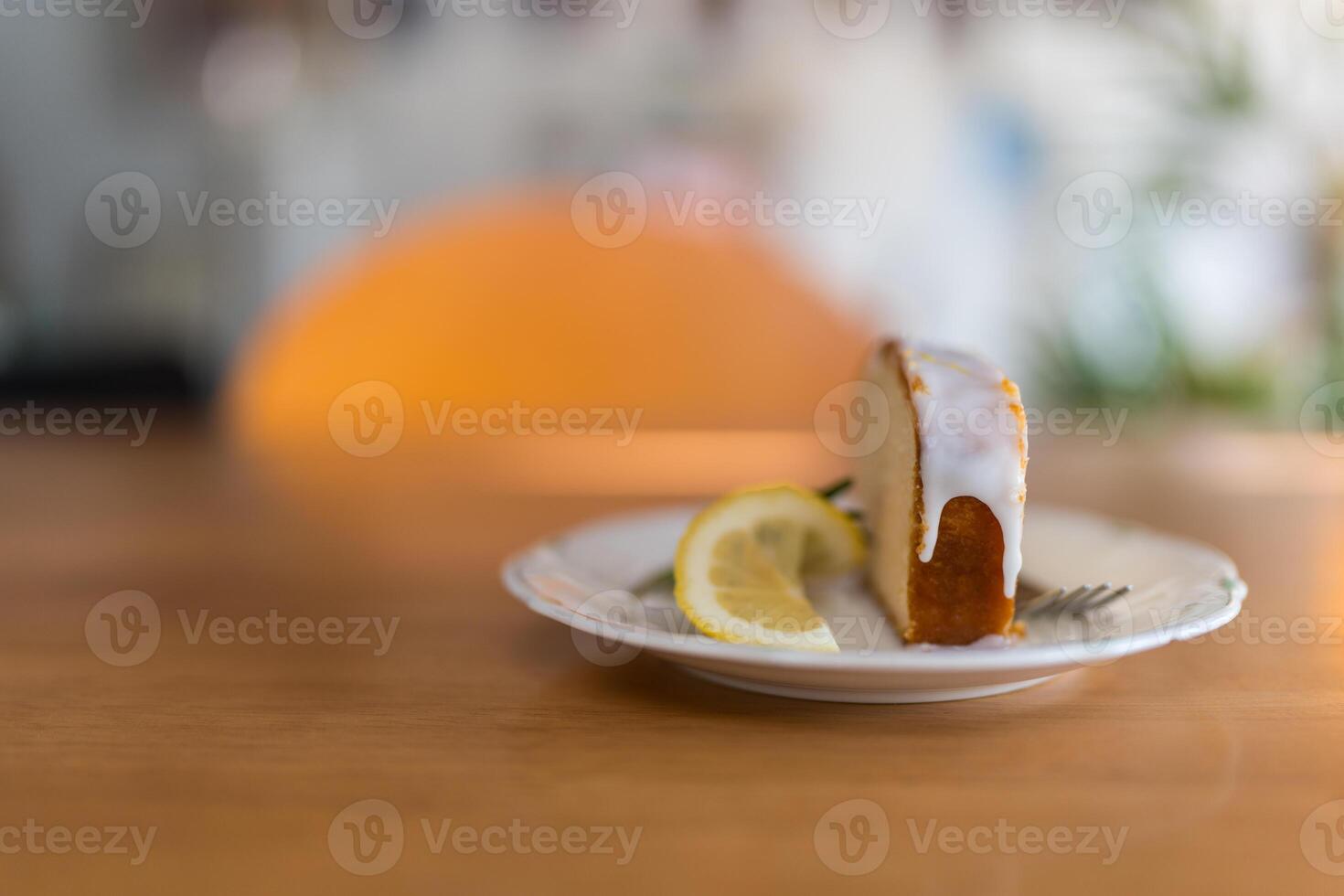 Slice of a lemon cake with lemon slice served on a white plate photo