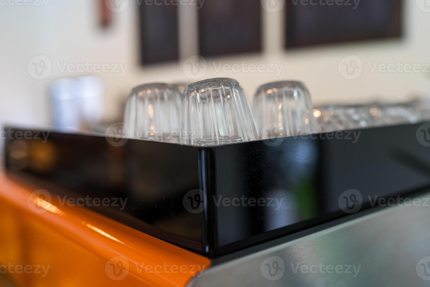 Glass coffee cups lie upside down on a coffee machine in a cafe photo