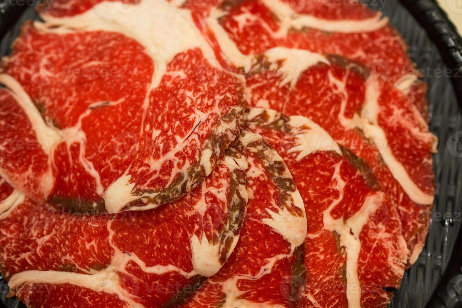 Raw beef neatly arranged in a black container photo