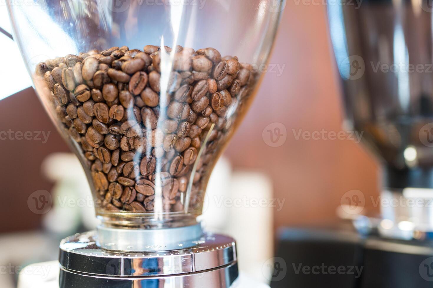 Freshly roasted coffee beans into the grinder close up shot photo