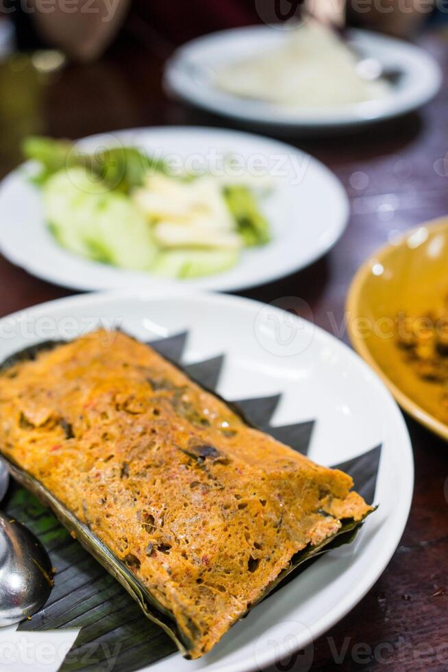 Steamed fish curry custard in banana leaf photo