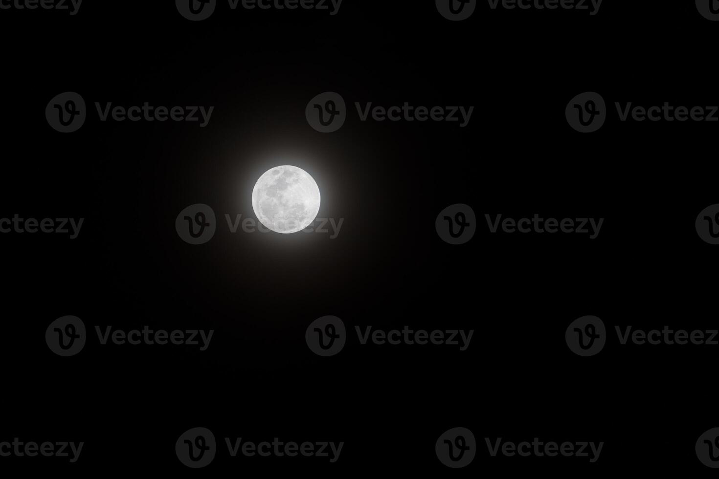 Bright full moon shines against deep night sky. photo