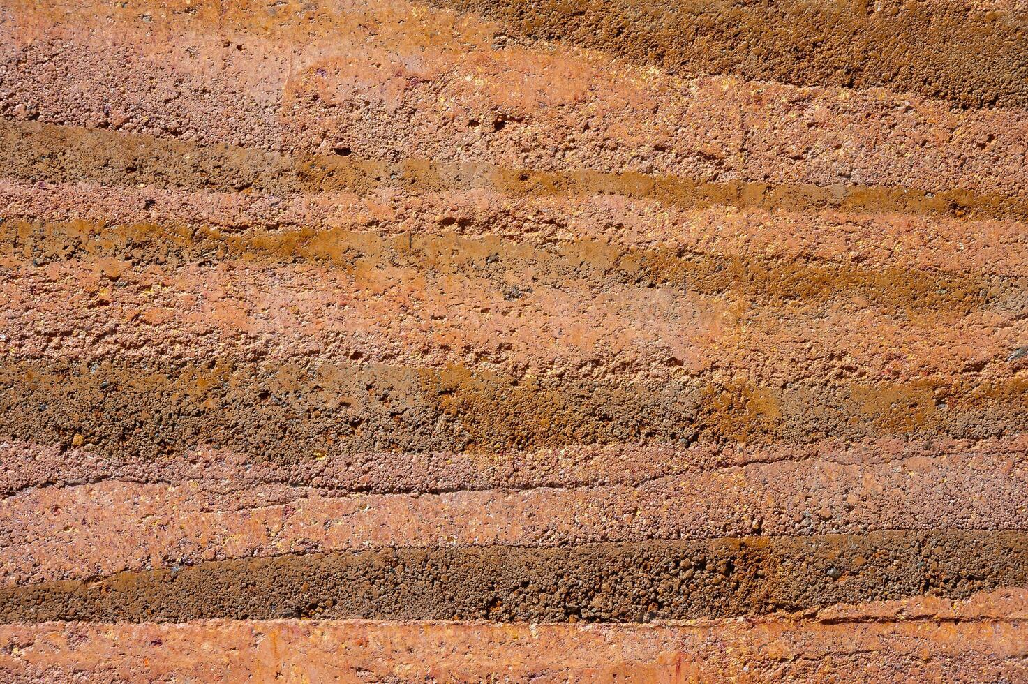 An earthen wall texture of clay house structure. These walls are constructed by ramming a mixture of aggregates, including gravel, sand, silt and a small amount of clay. photo