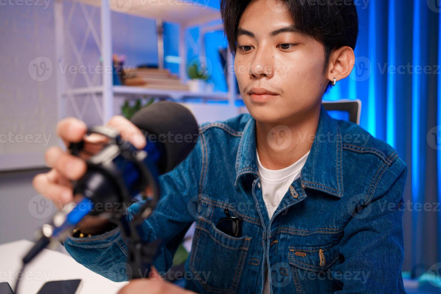 Content creator adjusting microphone for podcast recording in home studio photo