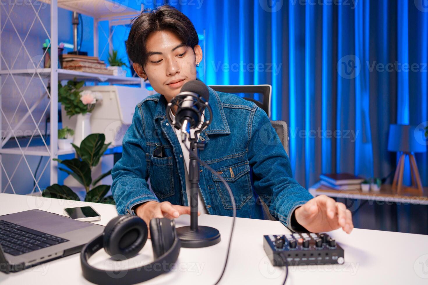 Podcast creator prepare and adjusting audio mixer in home studio photo