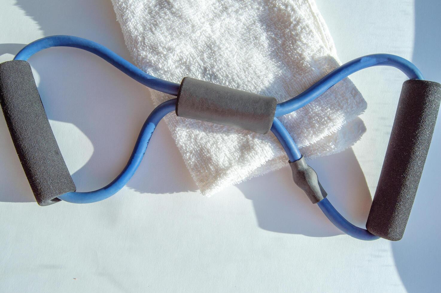 A banner with fitness training accessories, a towel and a hand-held rubber expander in the sunshine.. photo