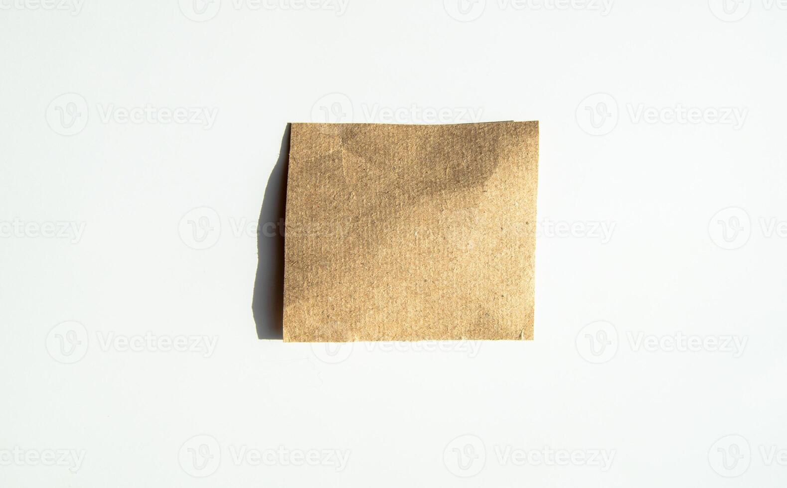 Square kraft sticker, sheet of brown note paper, isolated on a white background photo