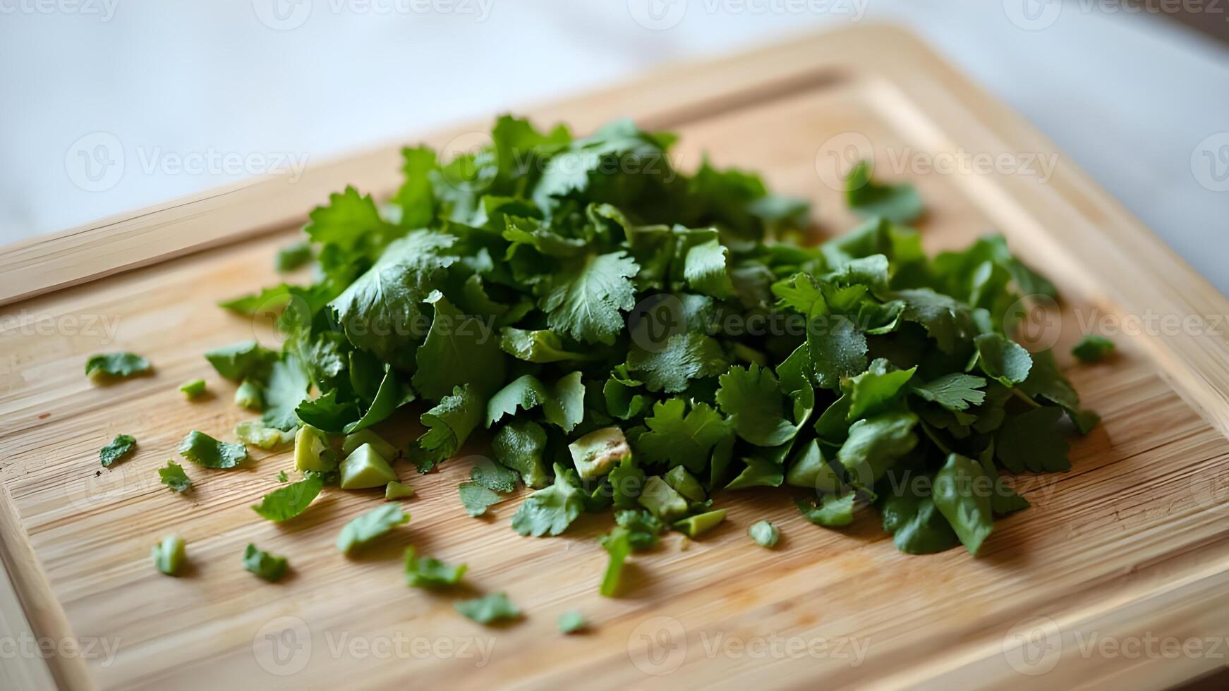 Flat lay of green herbs chopped and neatly placed on a smooth bamboo cutting board photo