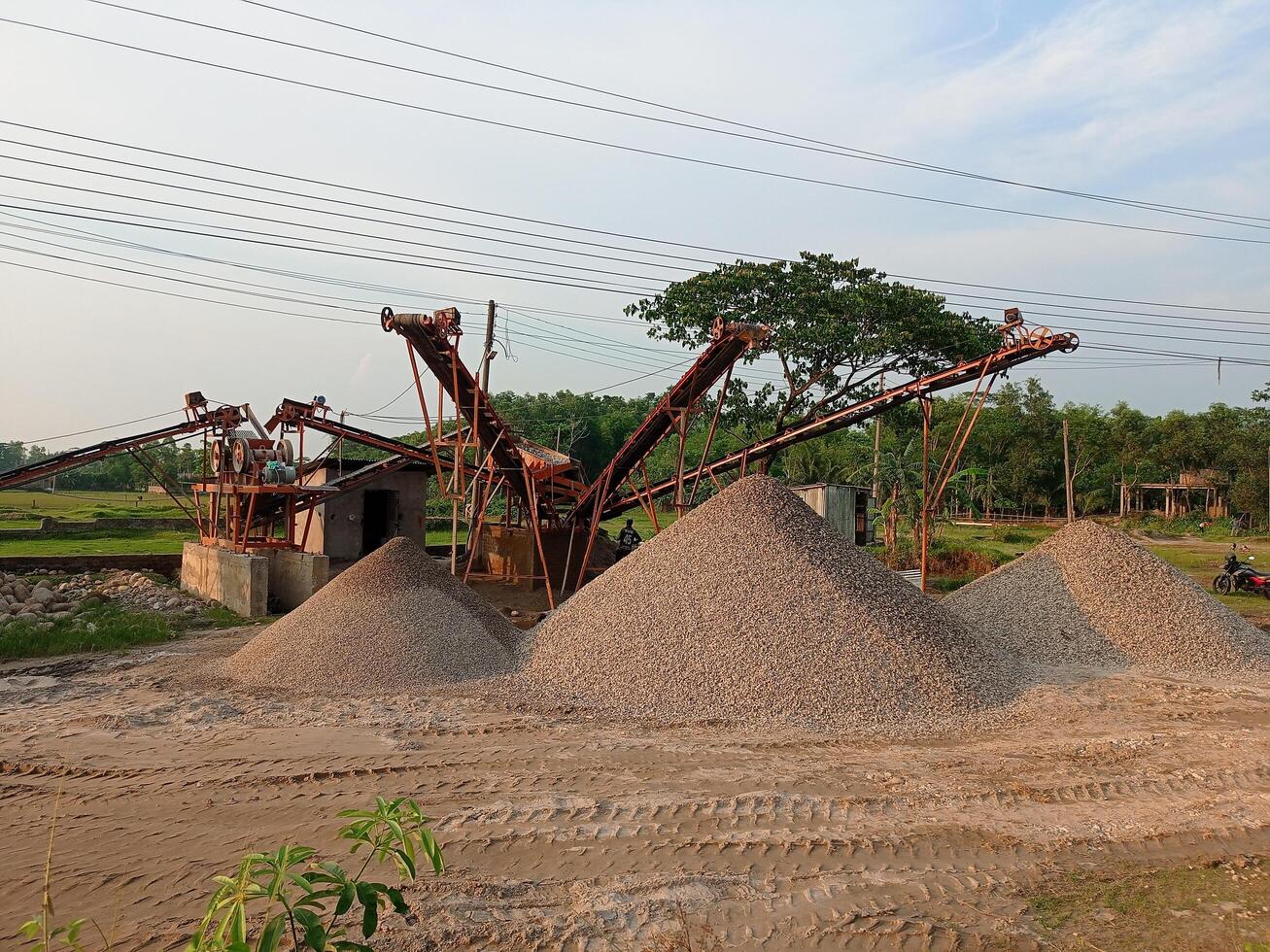 a pile of gravel sitting in the dirt next to a power line photo