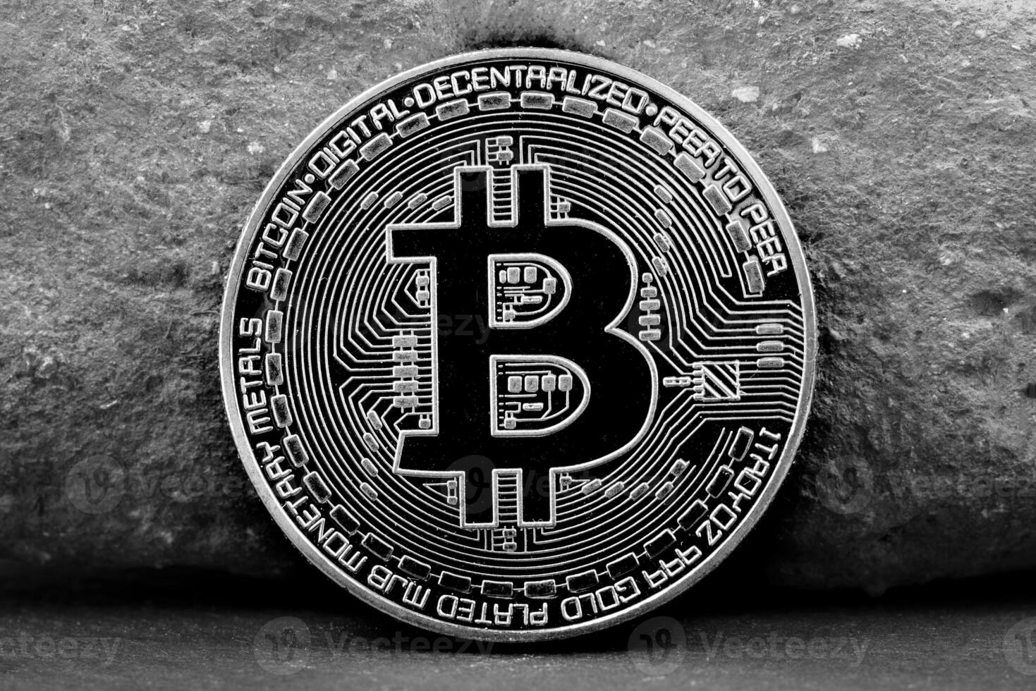 Black and white Bitcoin coin with engraved circuitry details photo