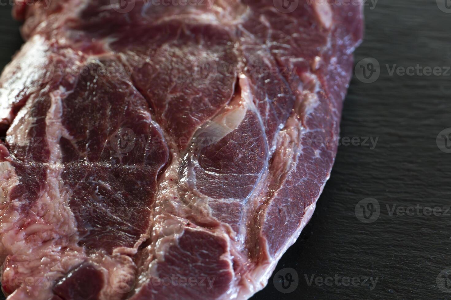 Raw Beef Steak on Black Stone Close-Up of Premium Marbled Meat Cut photo
