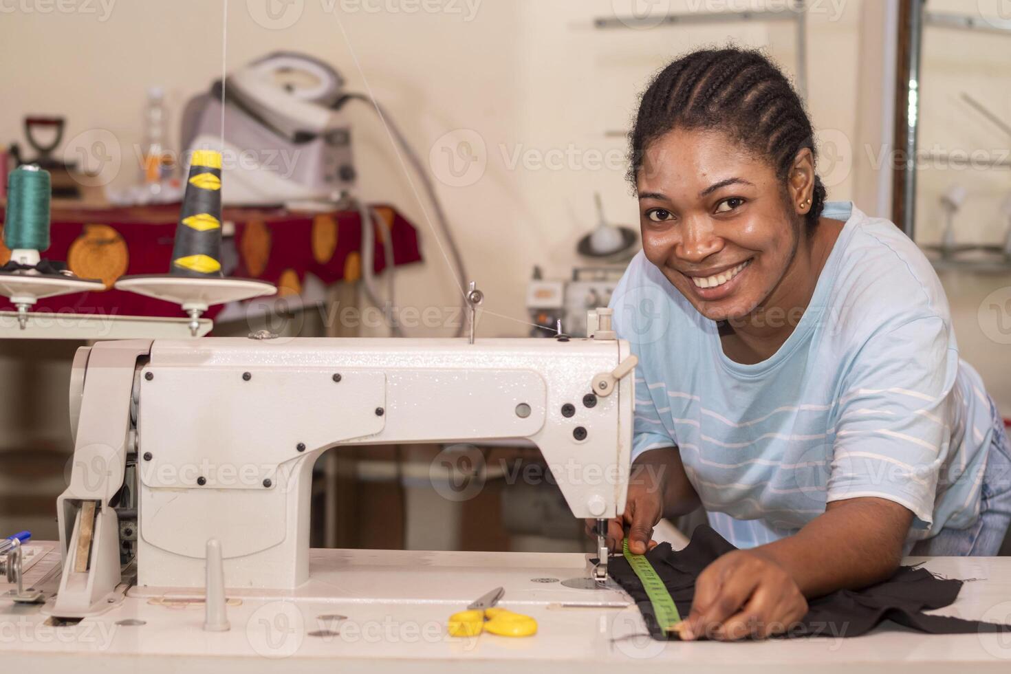 tailor working on a sewing machine, stitching fabric together at the shop photo