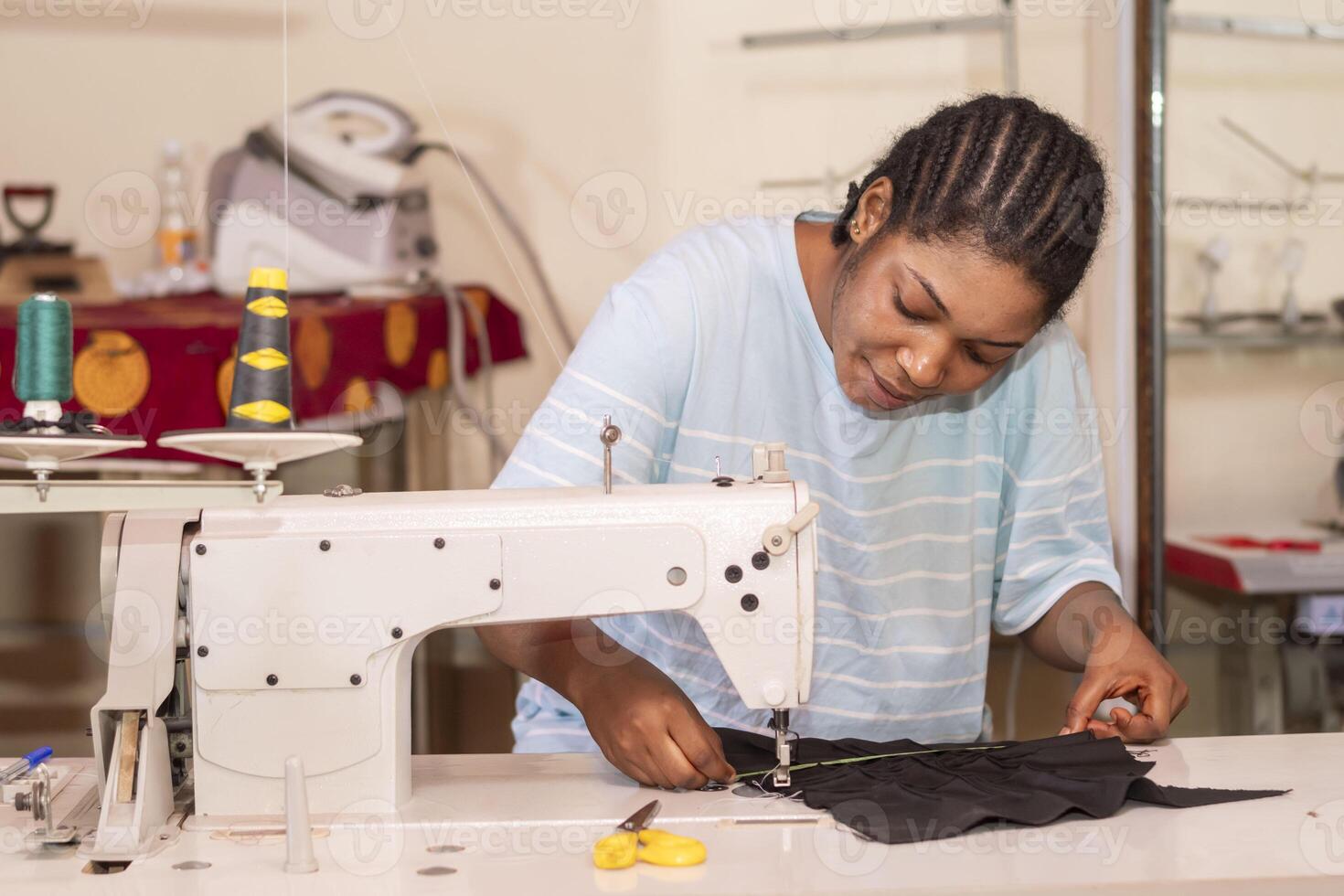 lady work on a sewing machine, stitching fabric together at the shop photo