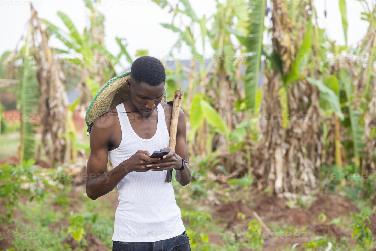 happy man using mobile phone in their farm land photo