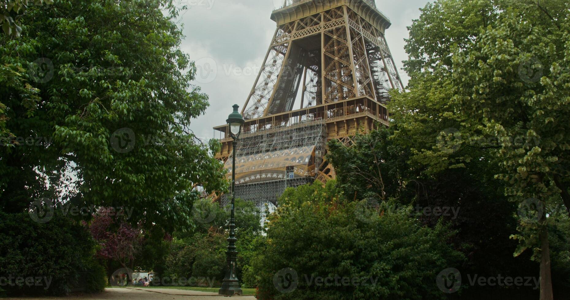 Beautiful view of the eiffel tower, the view moving from the foot, hidden among the dense green foliage, to the spire. France Paris. 4k , red komodo photo