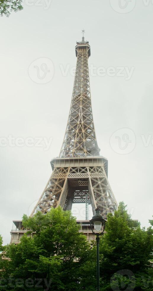 Bottom view of Eiffel Tower on a sunny summer day. Spire reconstruction. France Paris. 4k vertical , red komodo photo