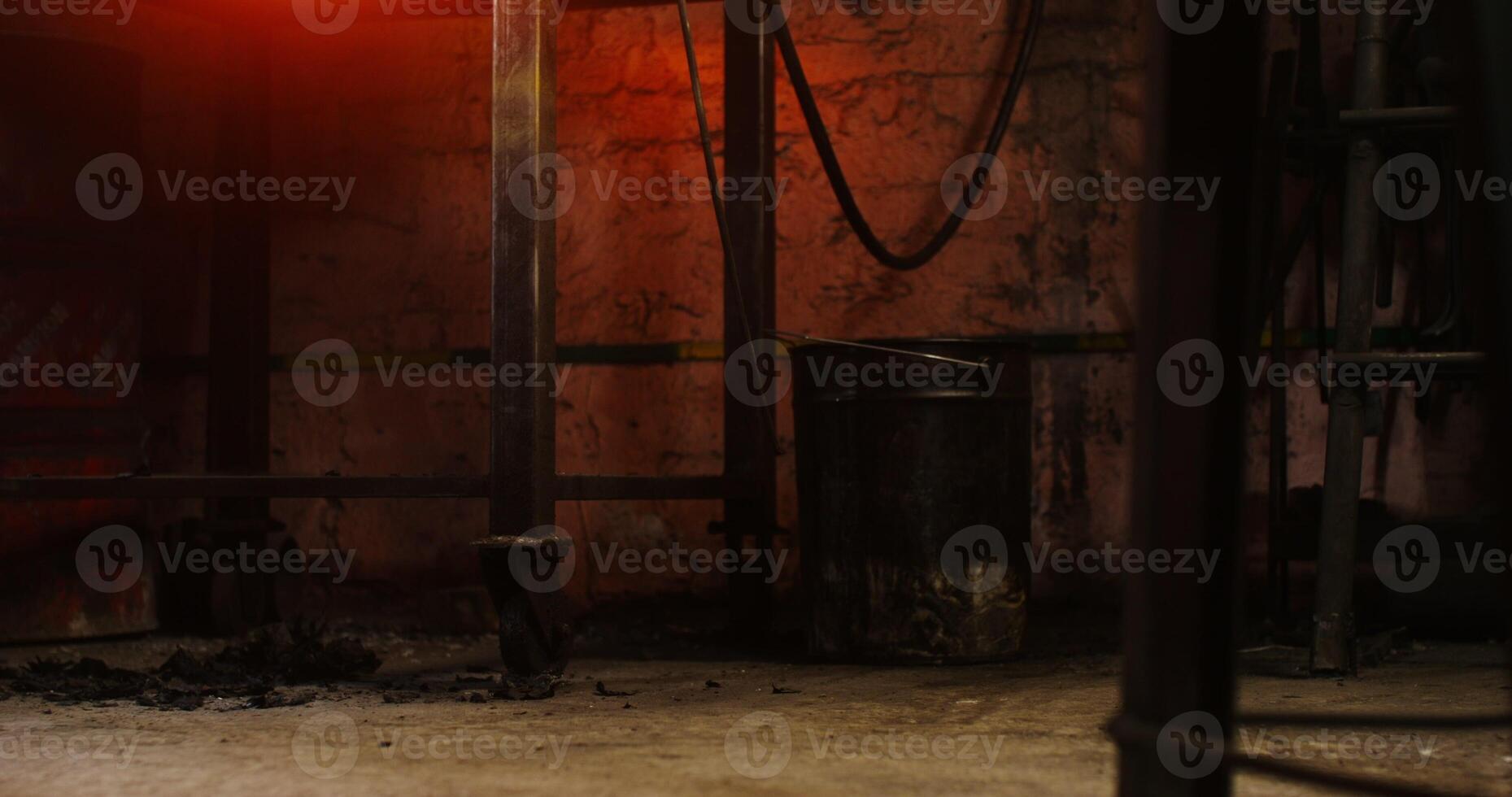 A man in leather boots and an apron walks around the forge, a close up of male legs. Ashes and coals lie on the floor. in 4k, red komodo photo