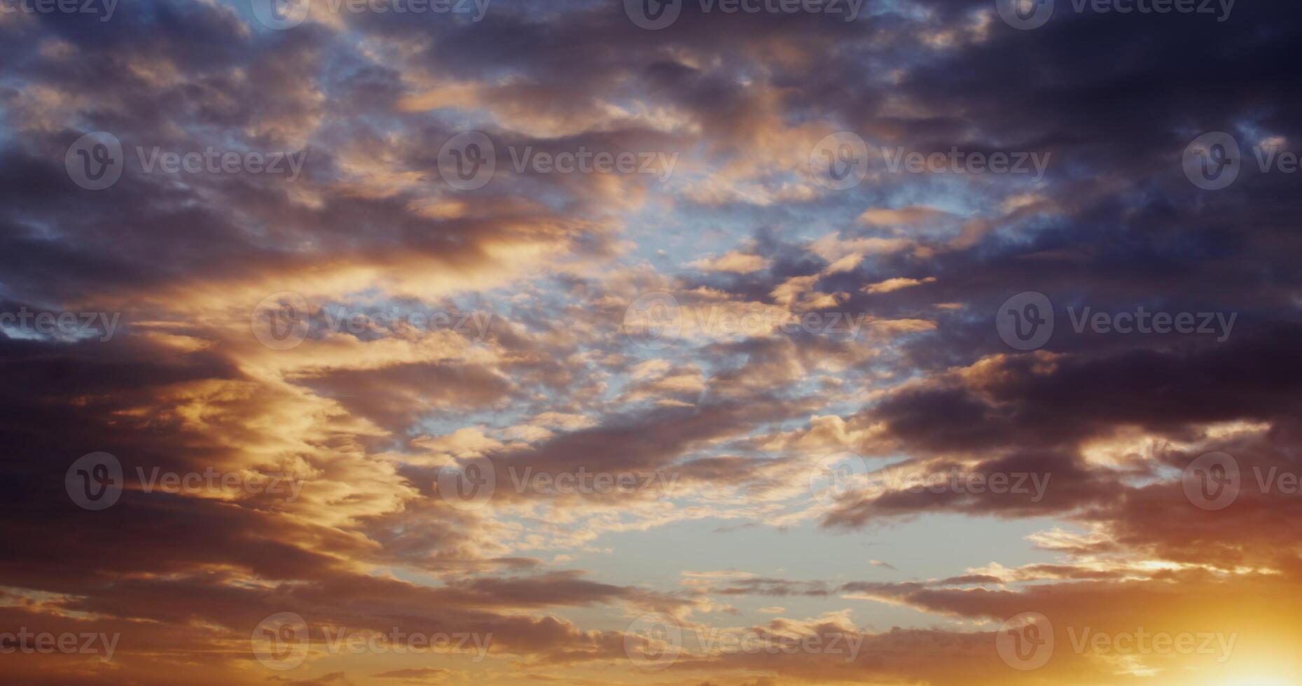 View of sky covered with thick clouds illuminated by the bright light of the rising sun. The bright yellow sun breaks through the clouds. in 4k, red komodo photo
