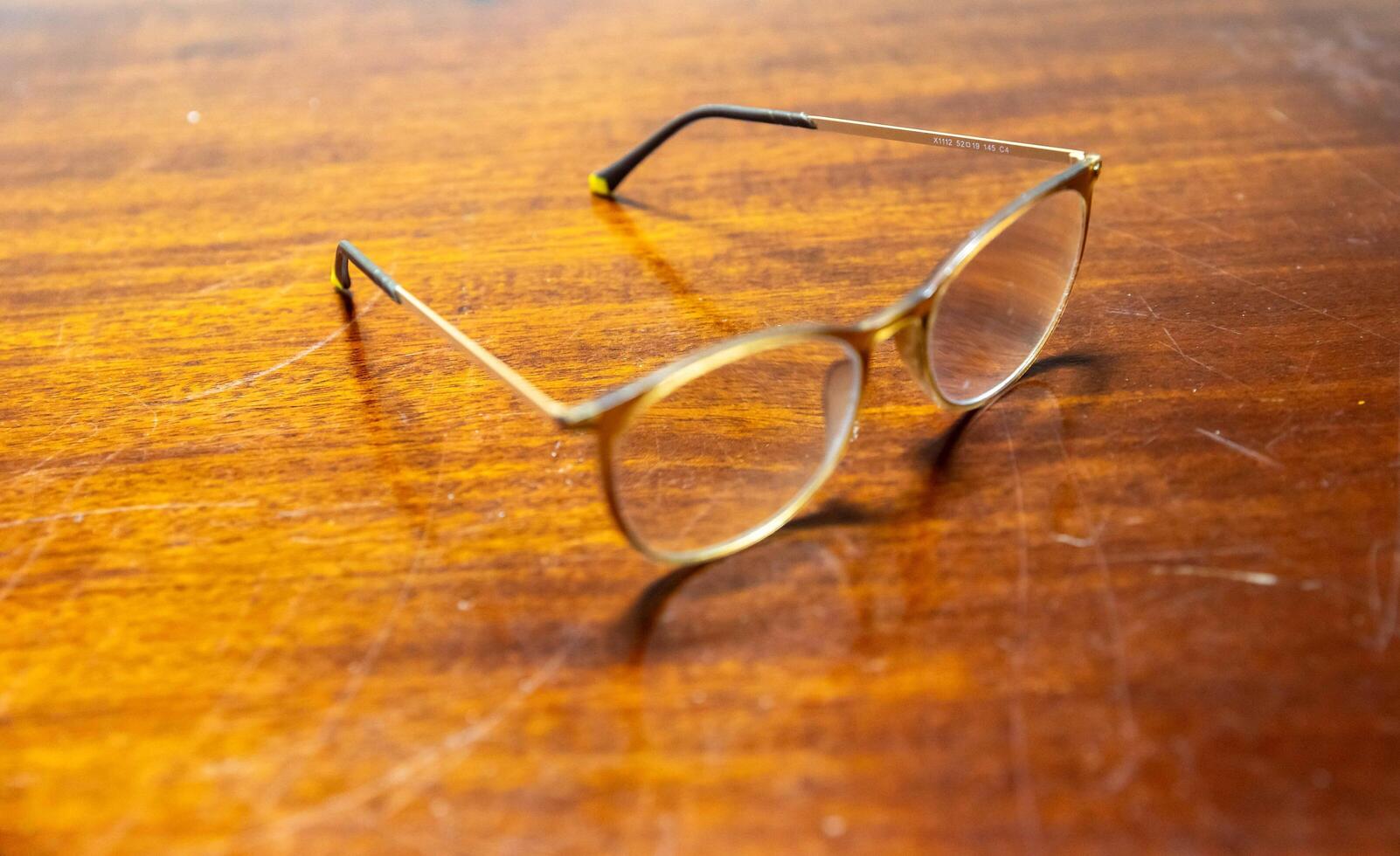 Classic frame prescription glasses isolated on rustic wooden table in selective focus. close up photo