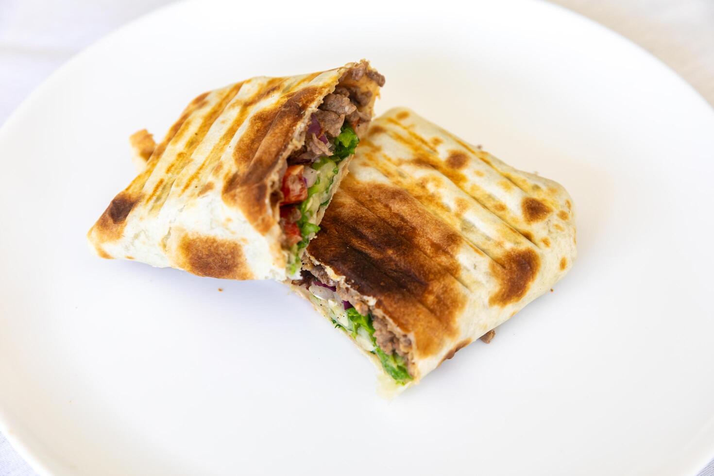 Close-up of a delicious shawarma wrap held in hand delitious photo